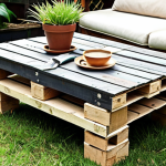 **A cozy garden coffee table made from repurposed wooden pallets:** Focus on a rustic aesthetic, emphasizing the natural wood grain, possibly with plants or garden tools nearby. Capture the satisfaction of DIY craftsmanship.